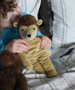 A child cuddling the Senger small floppy hedgehog soft toy, the child has both his hands holding the hedgehogs shoulders. The hedgehog is part of a wider selection of soft toys made with organic cotton and natural fillings that are available at Babipur. 