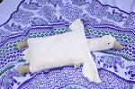 A Senger white organic cotton goose pillow placed on a blue and white patterned blanket. 