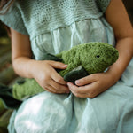 A closeup of a little girl cradling a Senger organic cotton cuddly stuffed fish toy