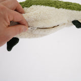 A hand unzipping the organic cotton Senger green fish cuddly toy