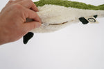 A hand unzipping the organic cotton Senger green fish cuddly toy