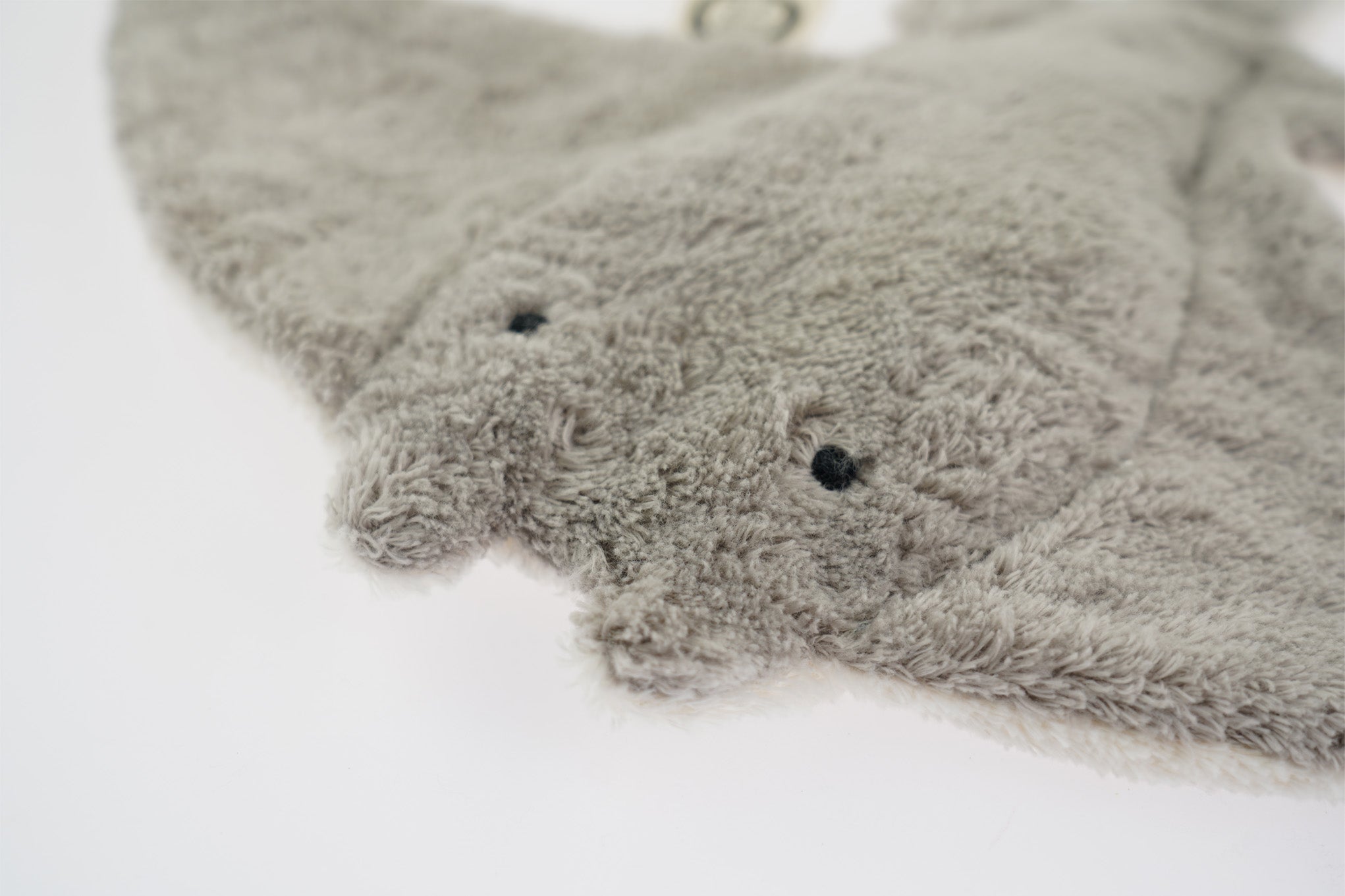 A closeup of the Senger organic cotton stuffed manta ray's cute face