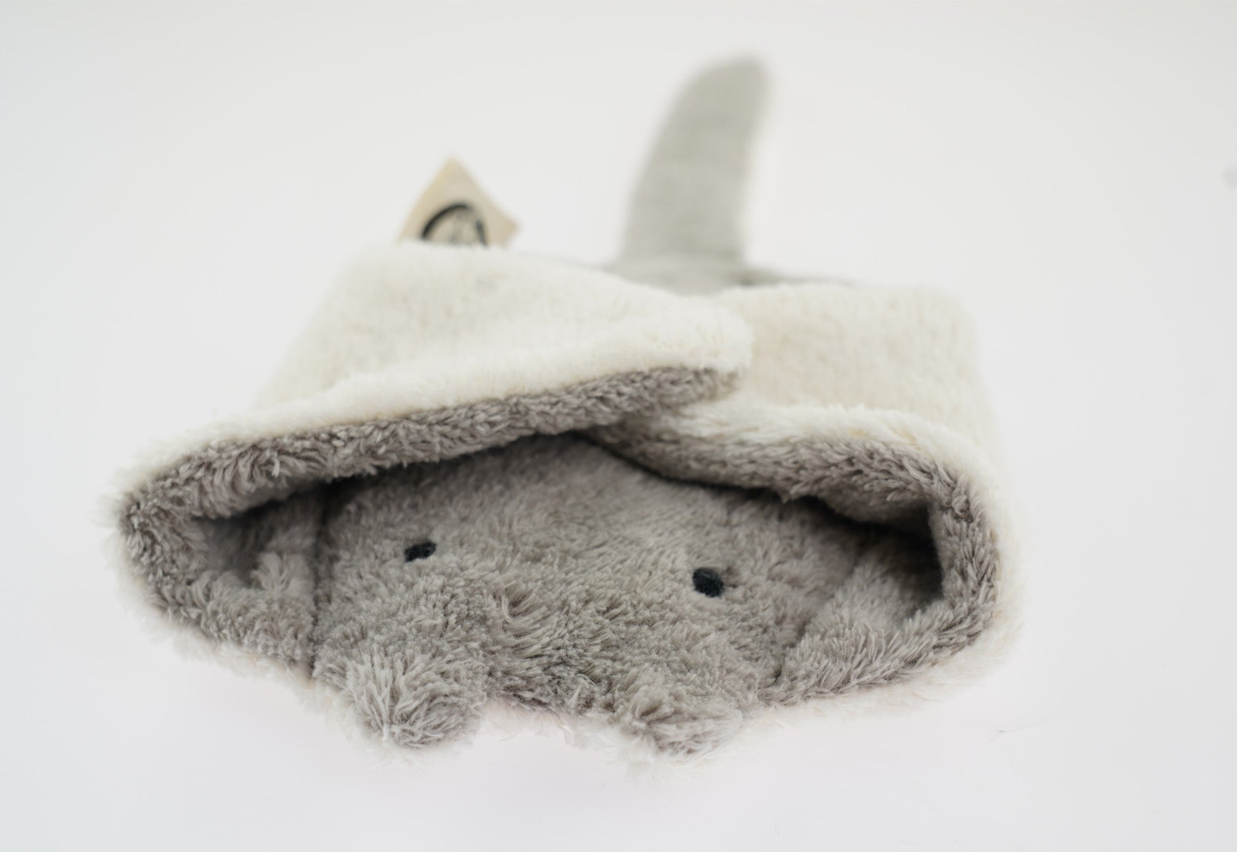 The Senger organic cotton grey stuffed manta ray cuddly toy, with its fins folded over its head