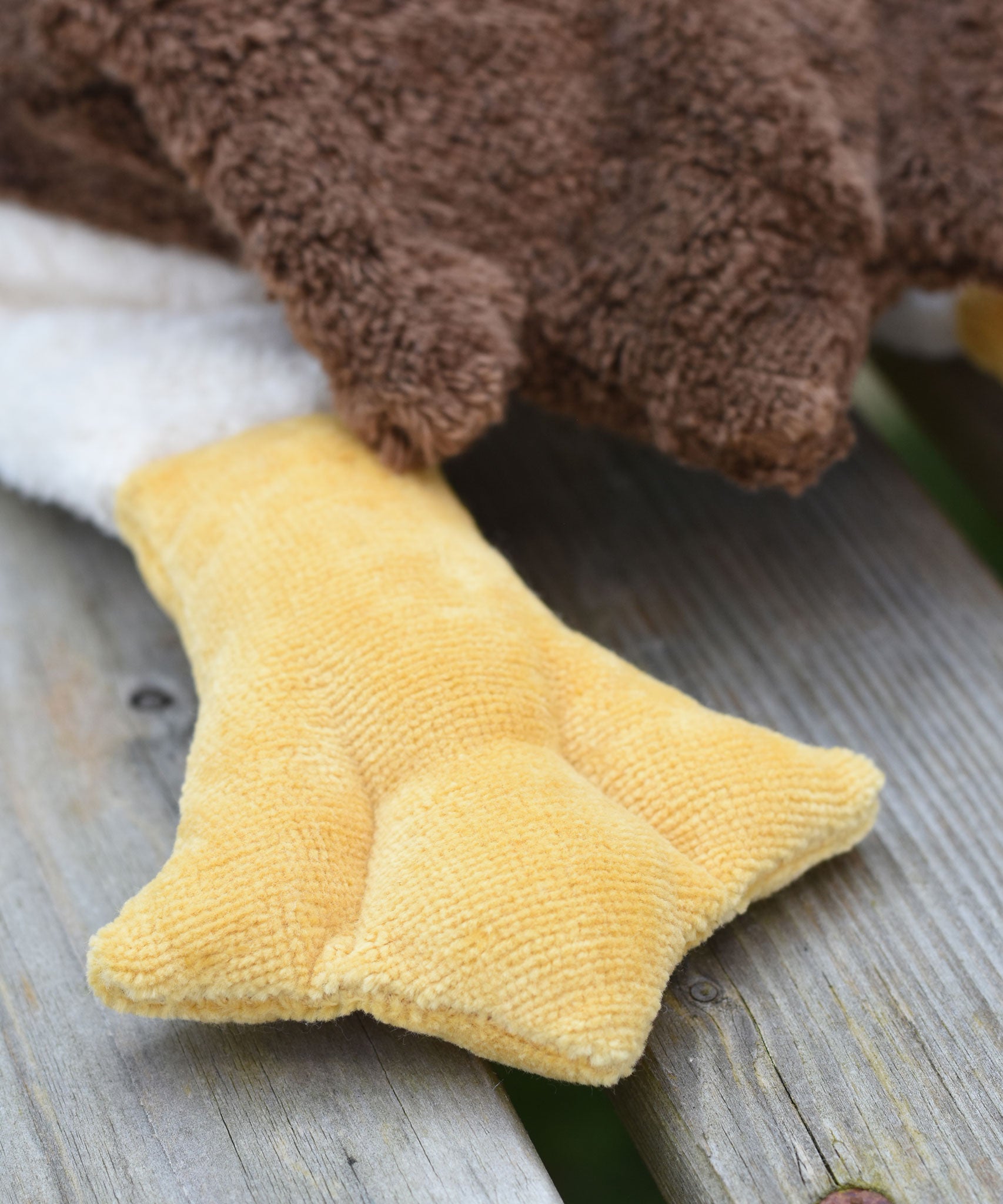 A close up of one of the yellow coloured flippers on the Senger Large Cuddly Drake Duck soft toy.