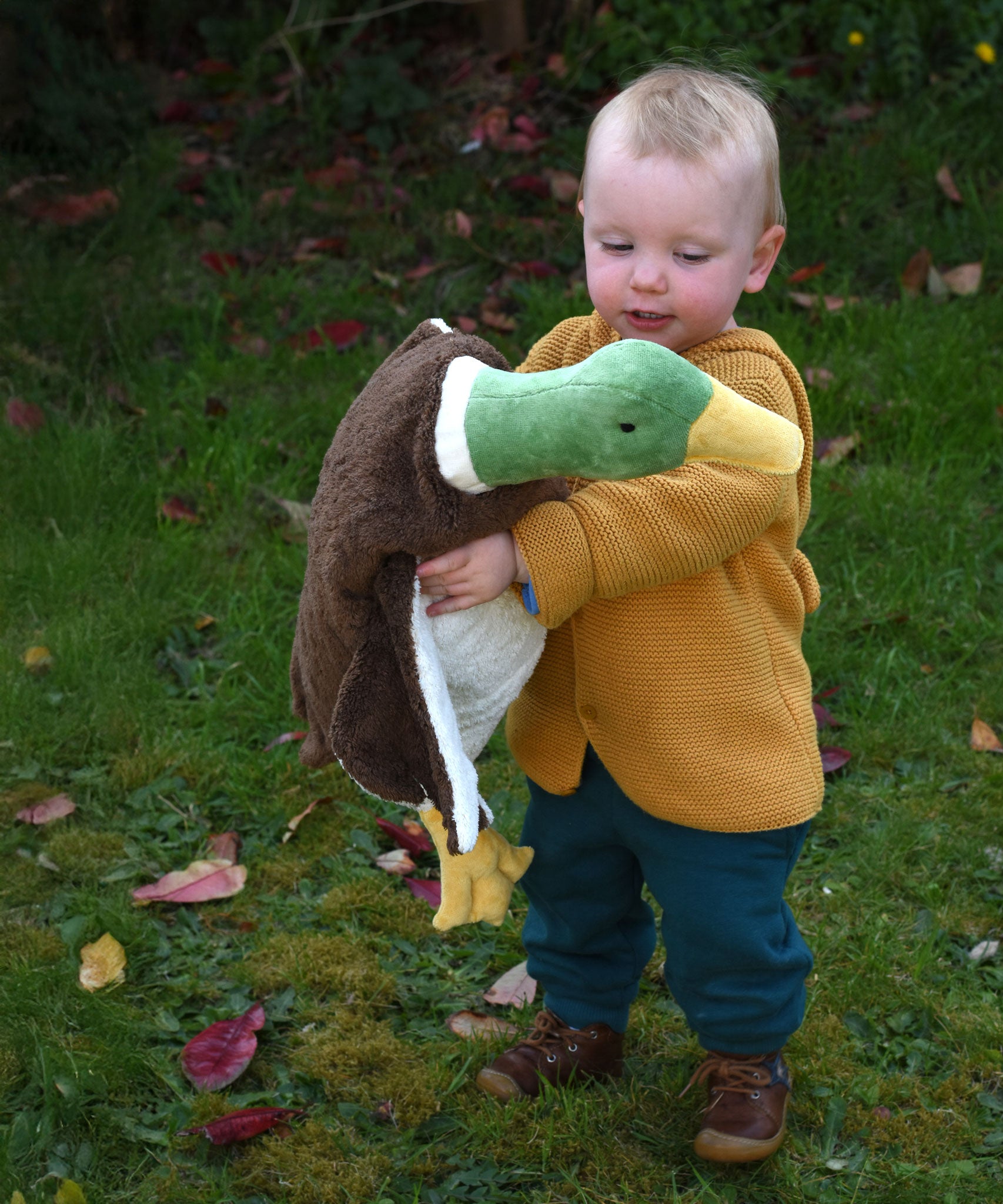 A Senger Large Cuddly Drake Duck soft toy  being carried by a young child.