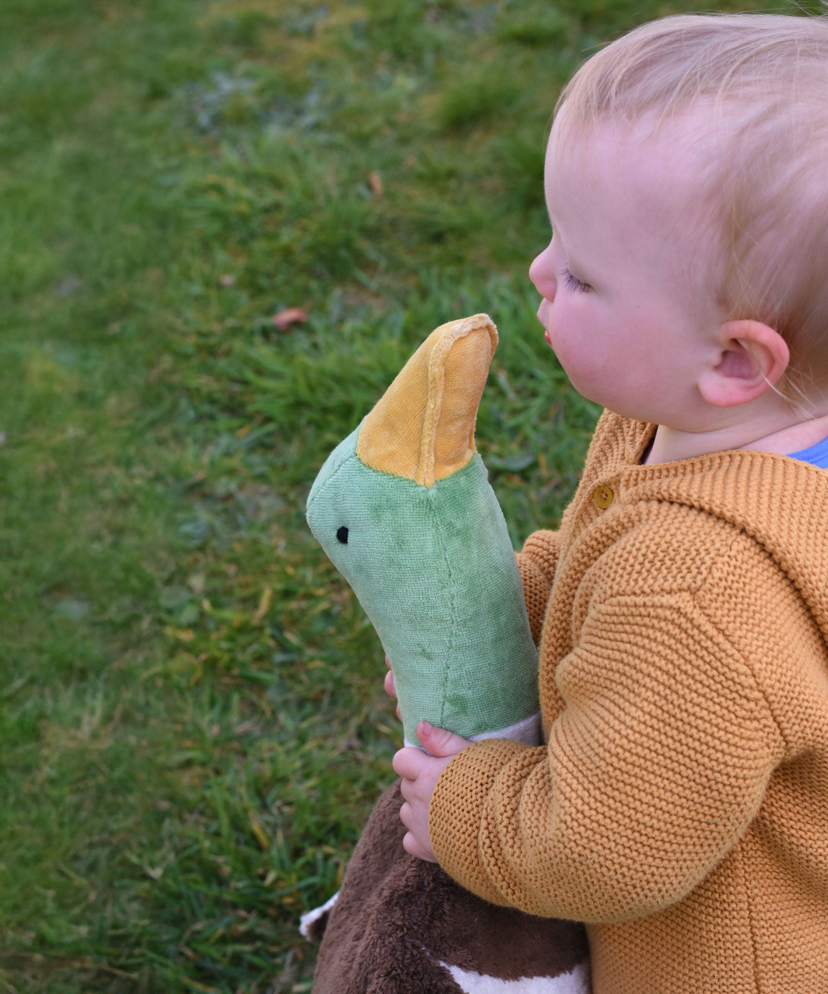 A close up of the head of the Senger Large Cuddly Drake Duck. The soft toy is being held by a young child.