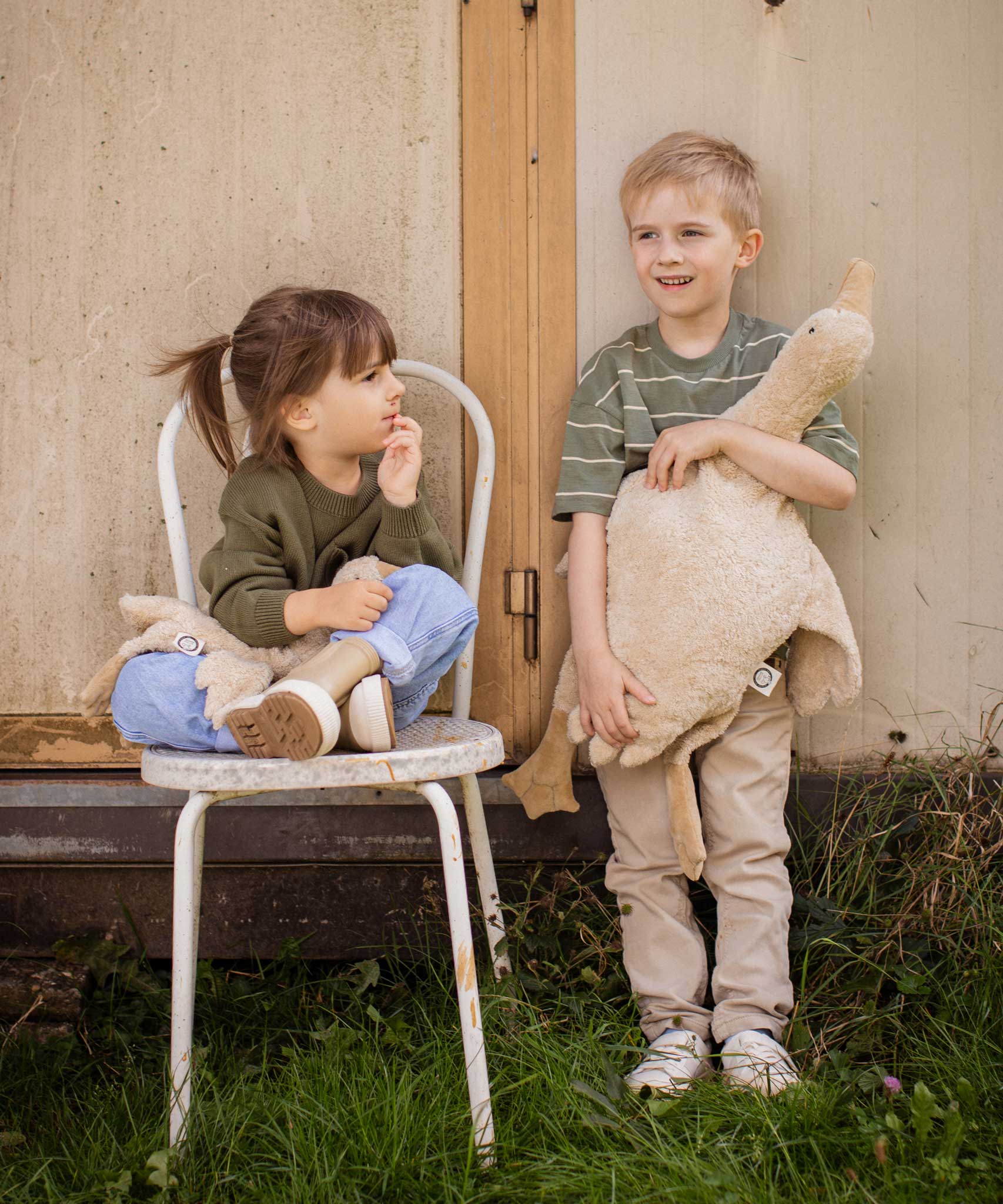 A child holding a Senger Large Cuddly Goose organic soft toy in a creamy Linen colour. Another child is sitting on a chair besides them holding the smaller version of the goose. These soft toys are created from the highest quality, sustainable and traceable natural materials. Senger cuddly animal toys and soft dolls are handmade in Germany with love and attention to detail and we are proud Senger stockists here at Babipur. 