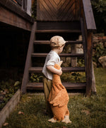A child holding a Senger Large Cuddly Goose organic soft toy in a dark orange Rust colour. These soft toys are created from the highest quality, sustainable and traceable natural materials. Senger cuddly animal toys and soft dolls are handmade in Germany with love and attention to detail and we are proud Senger stockists here at Babipur. 