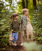 Two children holding hands walking in a forest, one is holding a Senger Large Cuddly Goose organic soft toy in a creamy Linen colour. The other child has the smaller version of the goose. These soft toys are created from the highest quality, sustainable and traceable natural materials. Senger cuddly animal toys and soft dolls are handmade in Germany with love and attention to detail and we are proud Senger stockists here at Babipur. 