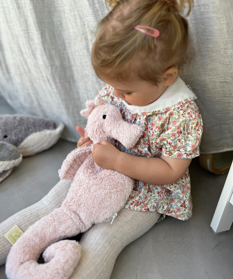 A child cuddling the Senger Large Cuddly Seahorse.
