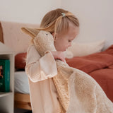 Child holding a large cream Senger cuddly goose soft toy in a bedroom