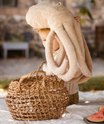 Child holding a Senger large cuddly octopus soft toy above a basket in the garden