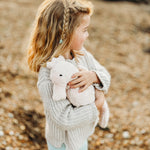 A child cudling the Senger Large Cuddly Seahorse soft toy.