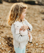 A child cudling the Senger Large Cuddly Seahorse soft toy.