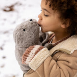 Child holding and kissing a large Senger grey cuddly soft toy in the snow