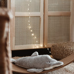 A Senger large organic cotton stuffed dolphin toy on a Wobbel board in a play room nursey