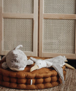 A Senger large organic cotton stuffed dolphin toy and a seagull toy on a cushion