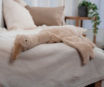 A Cuddly Goose organic soft toy in a creamy Linen colour placed on a sofa on a beige blanket. These soft toys are created from the highest quality, sustainable and traceable natural materials. Senger cuddly animal toys and soft dolls are handmade in Germany with love and attention to detail and we are proud Senger stockists here at Babipur. 