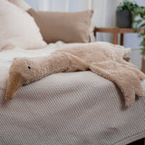A Cuddly Goose organic soft toy in a creamy Linen colour placed on a sofa on a beige blanket. These soft toys are created from the highest quality, sustainable and traceable natural materials. Senger cuddly animal toys and soft dolls are handmade in Germany with love and attention to detail and we are proud Senger stockists here at Babipur. 