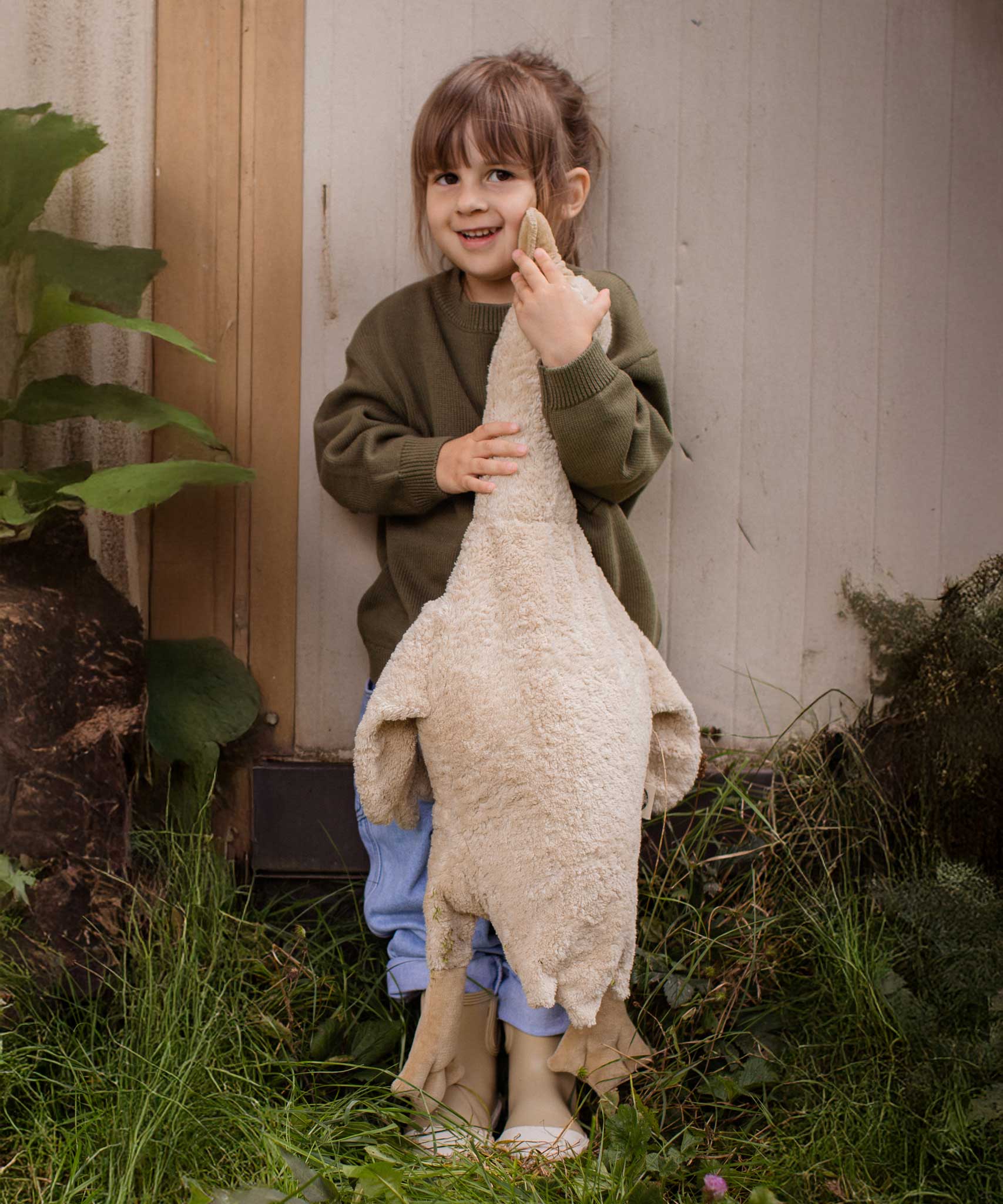 A child holding a Senger Large Cuddly Goose organic soft toy in a creamy Linen colour. These soft toys are created from the highest quality, sustainable and traceable natural materials. Senger cuddly animal toys and soft dolls are handmade in Germany with love and attention to detail and we are proud Senger stockists here at Babipur. 