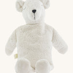A large soft cuddly white Senger polar bear toy sitting on a cream background. 