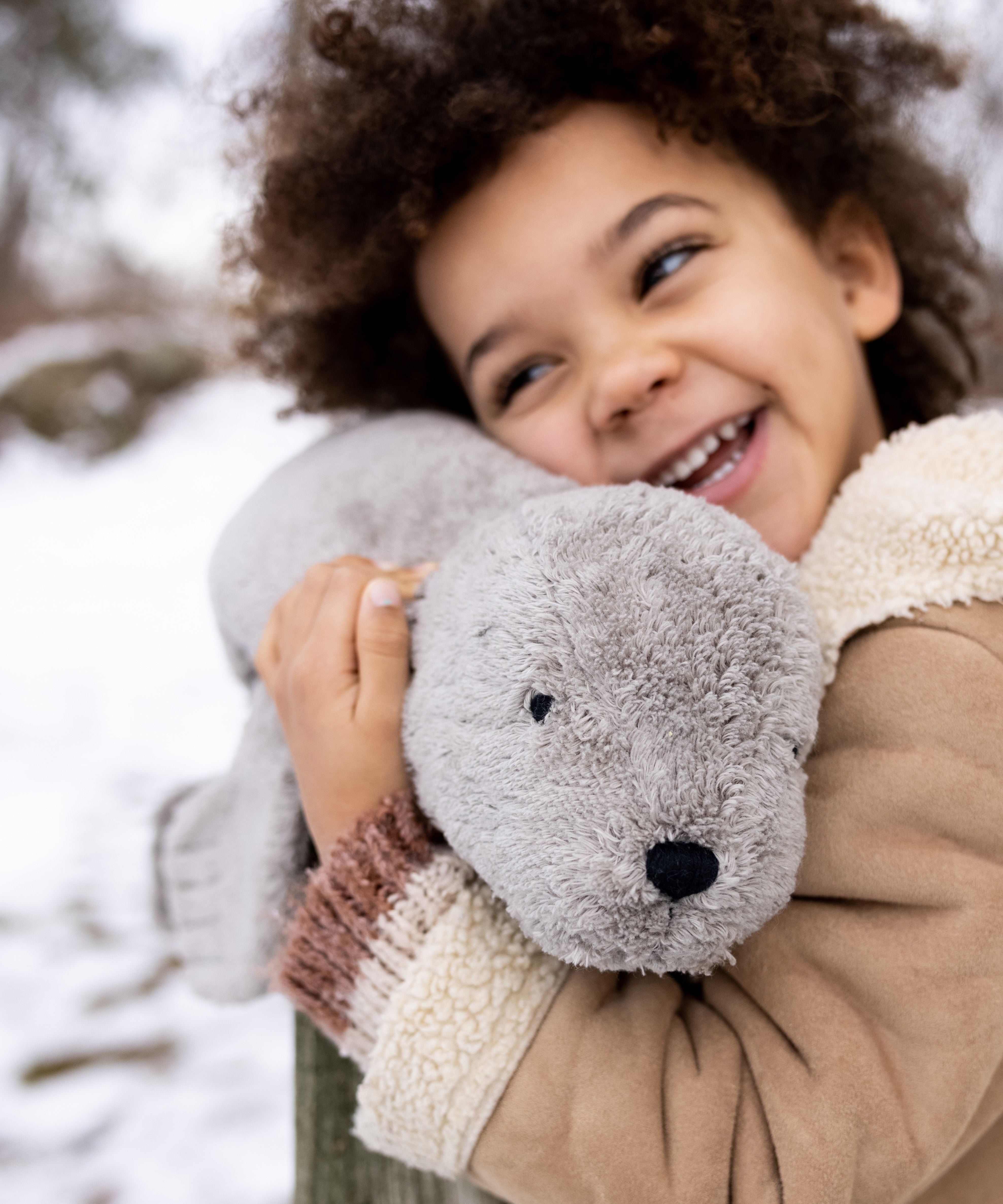 A child cuddling the large Senger grey seal.