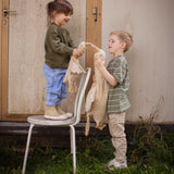 Two children holding a Senger Cuddly Goose organic soft toy in a creamy Linen colour. One is standing on a chair and holding a small goose the other is ho;ding a large goose. These soft toys are created from the highest quality, sustainable and traceable natural materials. Senger cuddly animal toys and soft dolls are handmade in Germany with love and attention to detail and we are proud Senger stockists here at Babipur. 
