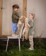 Two children holding a Senger Cuddly Goose organic soft toy in a creamy Linen colour. One is standing on a chair and holding a small goose the other is ho;ding a large goose. These soft toys are created from the highest quality, sustainable and traceable natural materials. Senger cuddly animal toys and soft dolls are handmade in Germany with love and attention to detail and we are proud Senger stockists here at Babipur. 