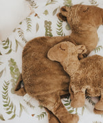 The large and small organic cotton stuffed camel toys on a bed