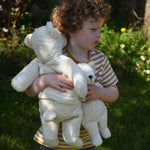 A child cuddling a Senger large and small cuddly polar bear soft toy in their arms.