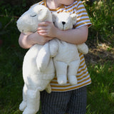 A close up of a child cuddling the Senger large and small cuddly polar bear soft toys in their arms.