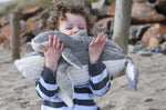 A child holding the large and small Senger cuddly whale animal soft toys.