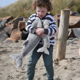 A child holding the large and small Senger cuddly whale animal soft toys with one in each arm.