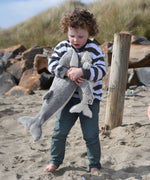 A child holding the large and small Senger cuddly whale animal soft toys with one in each arm.