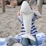 A child holding the large Senger cuddly whale soft toy up showing the whale's white underside.