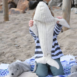 A child holding the large Senger cuddly whale soft toy up showing the whale's white underside.