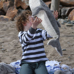 A child throwing the large Senger cuddly whale soft toy into the air.