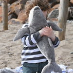 A child cuddling the large Senger cuddly whale soft toy.