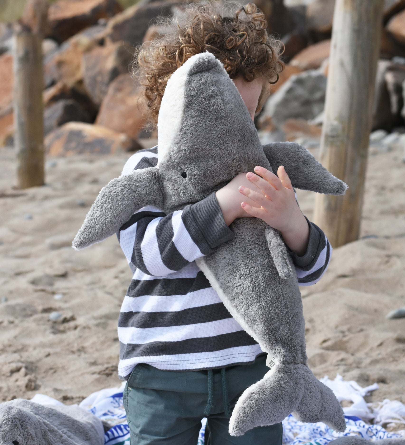 A child cuddling the large Senger cuddly whale soft toy.