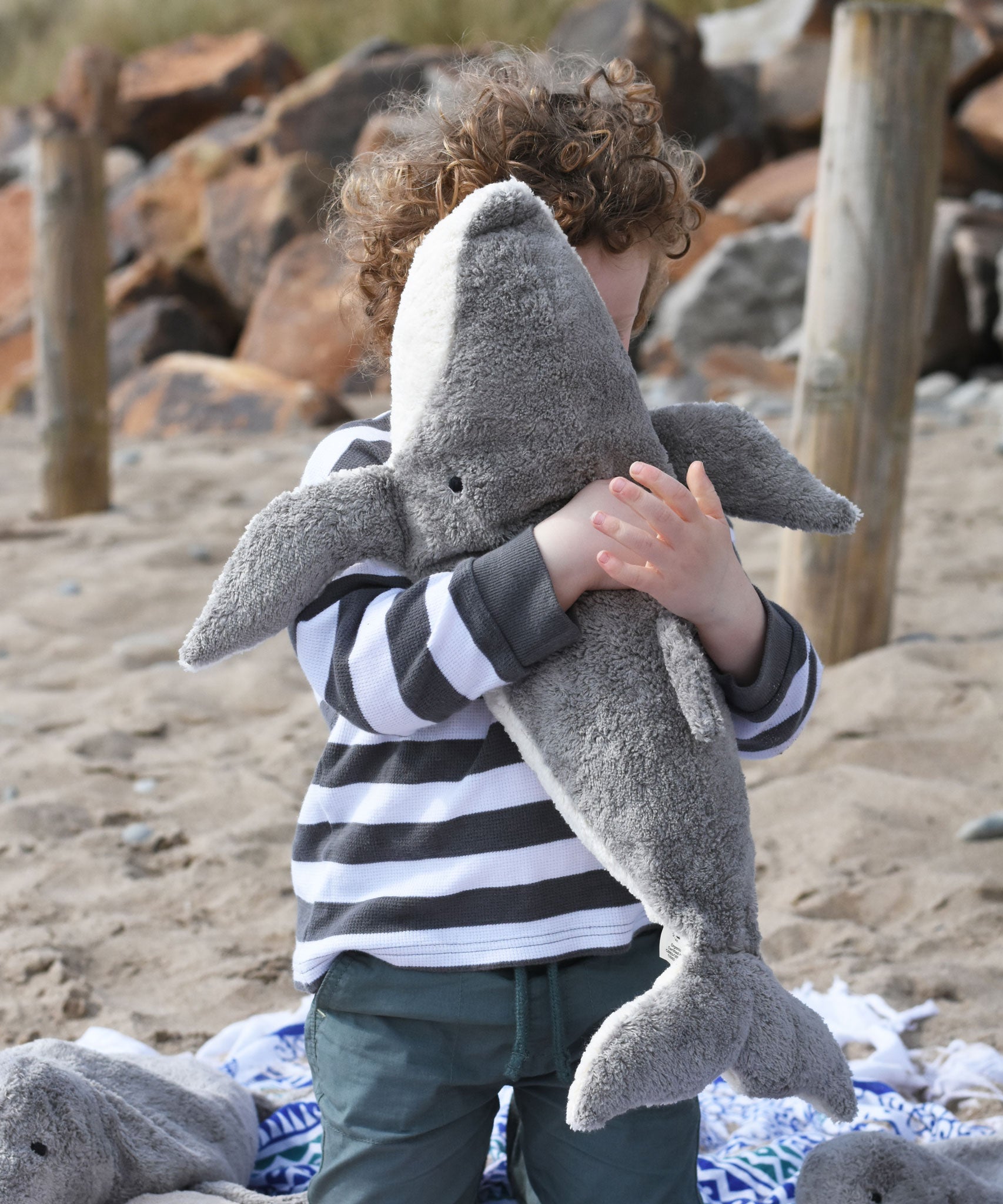 A child cuddling the large Senger cuddly whale soft toy.