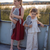 Two children holding the Senger Naturwelt Large Cuddly Shark outdoors, organic heatable soft toy with GOTS cotton outer and spelt husk cushion.