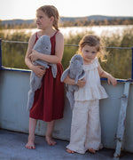 Two children holding the Senger Naturwelt Large Cuddly Shark outdoors, organic heatable soft toy with GOTS cotton outer and spelt husk cushion.