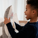 Child interacting with the Senger Naturwelt Large Cuddly Shark, organic heatable soft toy made from GOTS cotton plush and natural wool.