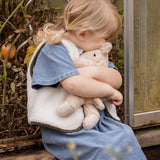 Child cuddling the Senger Naturwelt Small Cuddly Bear in Linen, organic heatable bear with removable cherry stone cushion.