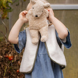 Child playing with the Senger Naturwelt Small Cuddly Bear in Linen, natural organic soft toy made from GOTS cotton.