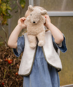 Child playing with the Senger Naturwelt Small Cuddly Bear in Linen, natural organic soft toy made from GOTS cotton.