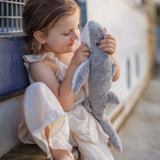 Child playing outdoors with the Senger Naturwelt Small Cuddly Shark, organic soft toy made from GOTS cotton plush and natural wool.
