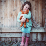 A little girl cuddling the Senger organic cotton small squirrel stuffed soft toy