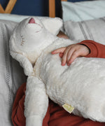 A close up of the Senger large white cuddly sheep soft toy being cuddled by a young child. This sheep is part of a wide range of soft toys made from organic and natural materials stocked at Babipur. 