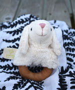 A Senger sheep baby grasping toy placed on a fern print Etta Loves sensory muslin cloth. 